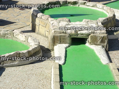 Stock image of miniature crazy golf course holes with green felt / tunnel