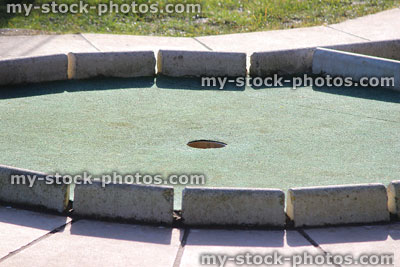 Stock image of hole at putting green on miniature golf course