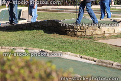 Stock image of families playing minigolf / miniature golf in park, putting green