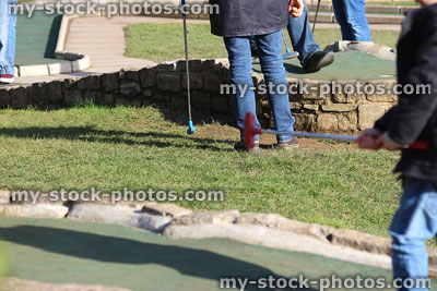 Stock image of families enjoying round of miniature golf / minigolf course