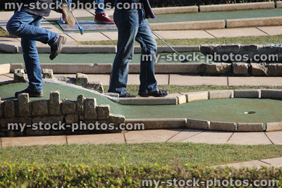 Stock image of children playing miniature golf game, mini golf course putting greens