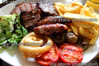 Stock image of mixed grill meal in restaurant, with steak, sausages, gammon, chips
