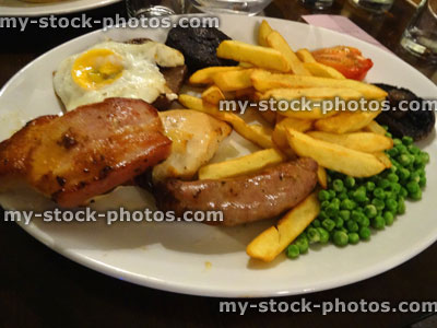 Stock image of restaurant mixed grill meal, steak, sausages, gammon, chips, fried egg, peas