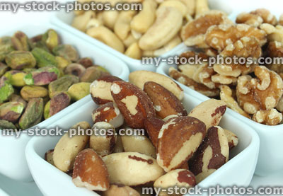 Stock image of mixed nuts in square dishes, cashews, walnuts, pistachios and brazils