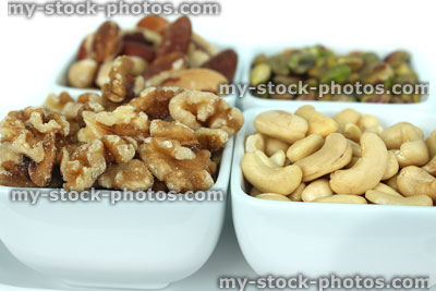 Stock image of dishes of healthy nuts, walnuts, cashews, brazil nuts, pistachios
