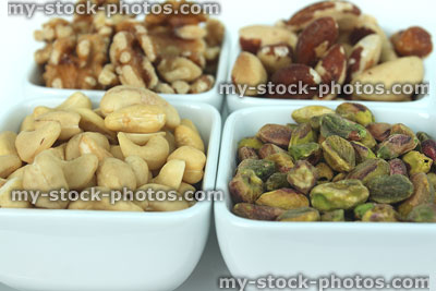 Stock image of healthy nuts (four dishes), walnuts, cashews, brazil nuts, pistachios