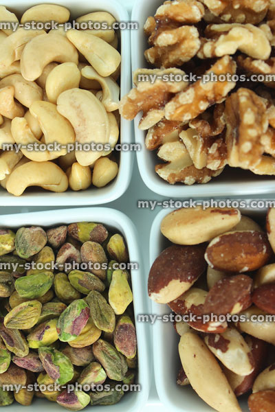 Stock image of mixed nuts in four dishes, cashews, walnuts, pistachios, brazil nuts, fibre
