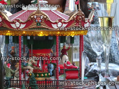 Stock image of model carousel roundabout on Christmas table with wine glasses