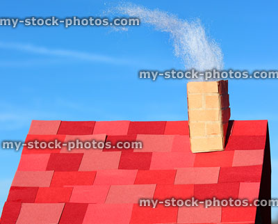 Stock image of homemade cardboard house with paper roof tiles, chimney smoke