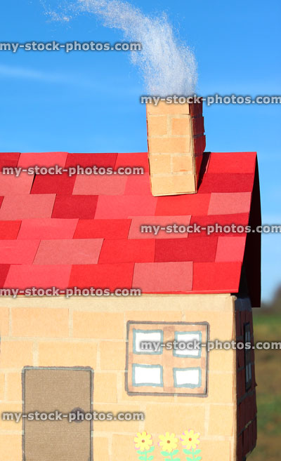 Stock image of homemade card house with red roof tiles, chimney