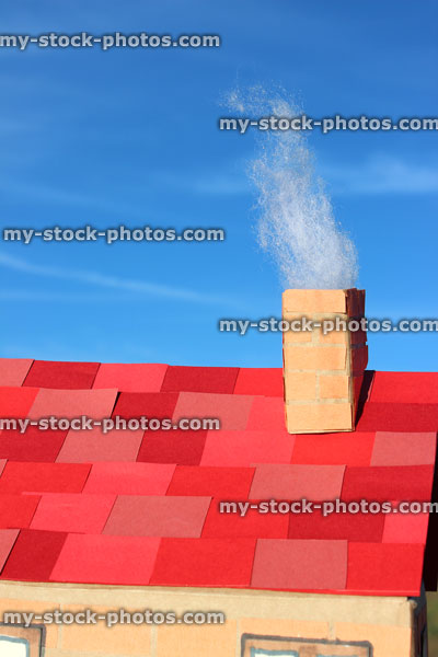 Stock image of cardboard dolls house with red roof tiles, chimney smoke