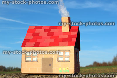 Stock image of miniature cottage house made from cardboard, red roof