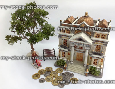 Stock image of model bank with toy coins, mother and child