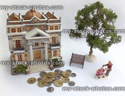 Stock image of model bank with toy coins, mother and child