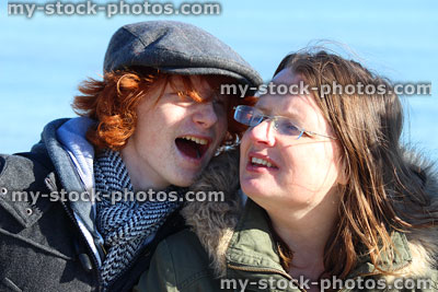 Stock image of mother and teenage son laughing together at beach