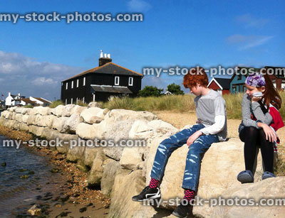 Stock image of children watching the tide at Mudeford Spit, Dorset, England, UK
