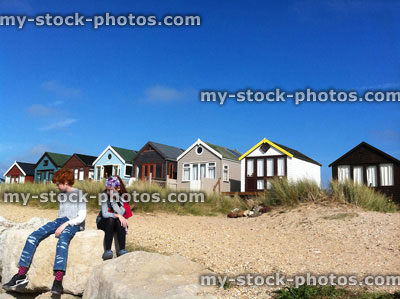 Stock image of children sat in thought at Mudeford Spit, Dorset, England, UK