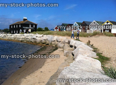 Stock image of children running past beach huts on Mudeford Spit, Dorset, England