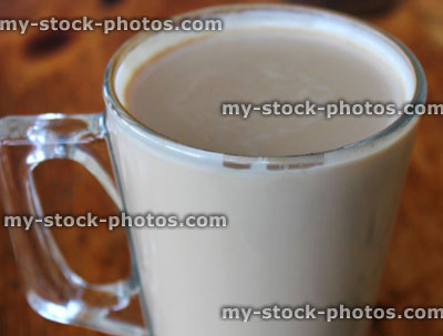 Stock image of glass mug of frothy coffee, cappuccino coffee cup, table