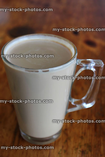 Stock image of glass mug of frothy coffee, cappuccino coffee cup, table