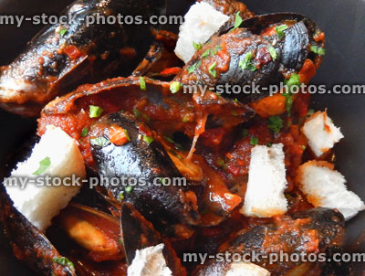 Stock image of seafood dish at restaurant, mussels, spicy tomato sauce, croutons