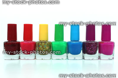 Stock image of colourful rainbow nail varnish bottles against white background