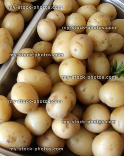 Stock image of freshly cooked new potatoes on silver platter, party food buffet