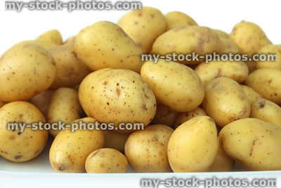 Stock image of small new potatoes on plate, vitamins and health benefits