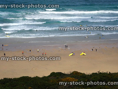 Stock image of surfers riding the whitewater waves on Cornish beach 