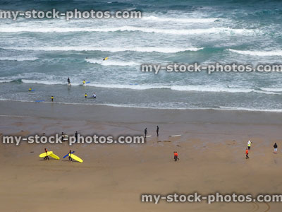 Stock image of surfers learning to surf on beach, Newquay, Cornwall