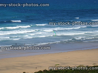 Stock image of a kiteboarder riding waves along Newquay, Cornwall coastline