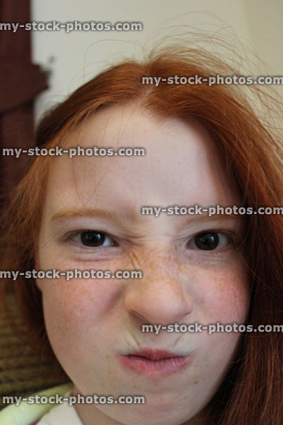 Stock image of young girl pulling angry face expression