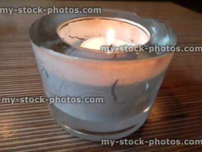 Stock image of burning nightlight candle flame in glass candle holder glass