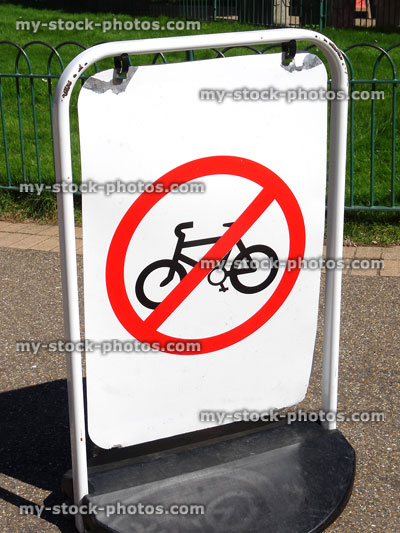 Stock image of no cycling sign in park, bicycling prohibited signpost