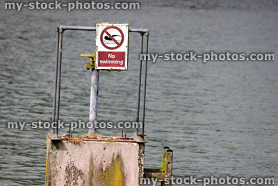 Stock image of 'No Swimming' sign in the middle of a fishing lake