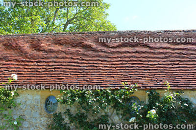 Stock image of old clay terracotta roof tiles, on historic cottage roof