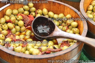 Stock image of wooden barrel of pitted green olives, farmer's market
