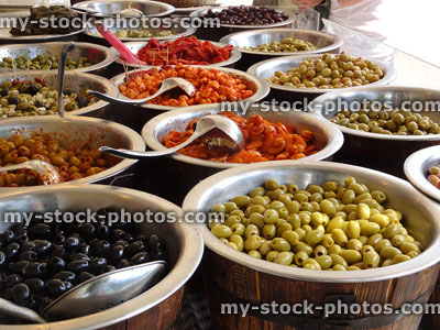 Stock image of barrels filled with stuffed olives at food market