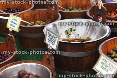 Stock image of wooden barrels of pitted green olives, farmer's market
