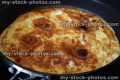 Stock image of spanish omelette / tortilla cooking in non stick frying pan, healthy meal