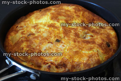 Stock image of spanish omelette / tortilla cooking in non stick frying pan, healthy meal