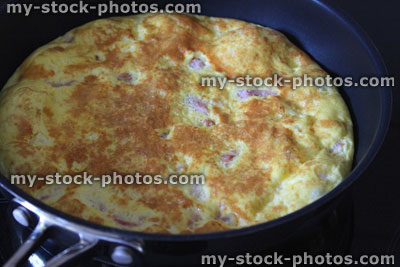 Stock image of bacon omelette / tortilla cooking in non stick frying pan, healthy meal