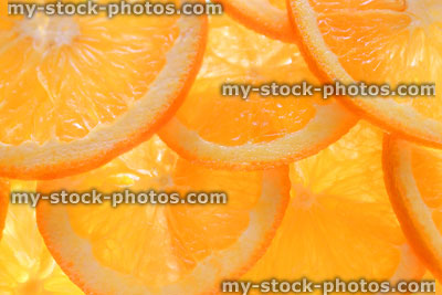 Stock image of orange slices / overlapping sliced citrus fruit background, backlit