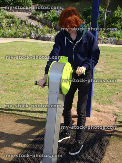 Stock image of boy using fitness equipment in outdoor gym park