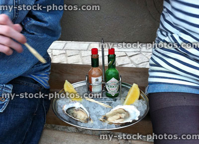 Stock image of tray of Shucked Oysters on crushed ice with Pepper Sauce