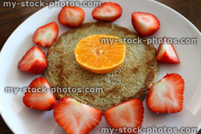 Stock image of small Scotch pancake 'flower' with strawberry petals, satsuma