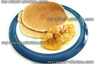 Stock image of fresh homemade pancakes on plate, with sliced apple, maple syrup