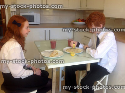 Stock image of children eating pancakes for breakfast with fruit smoothies