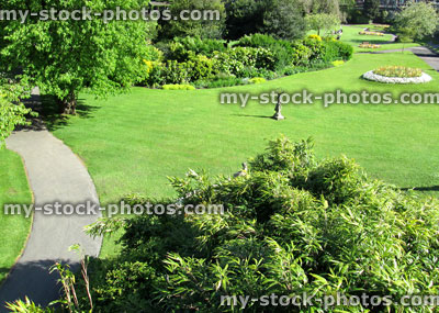 Stock image of park with expanse of green lawn grass, pathways and trees