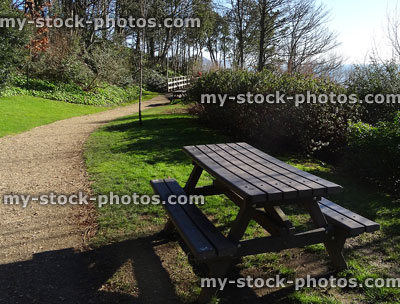 Stock image of outdoor picnic tables in park by gravel pathway